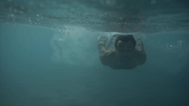 men run, splash and dive underwater