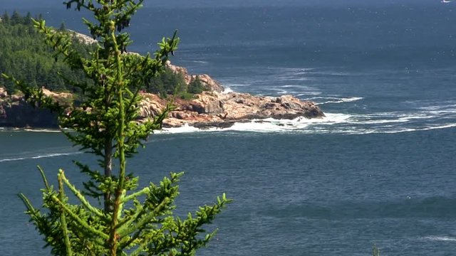 Waves crash onto rocky coastline at Acadia National Park in Maine.  Slow pan from left to right
