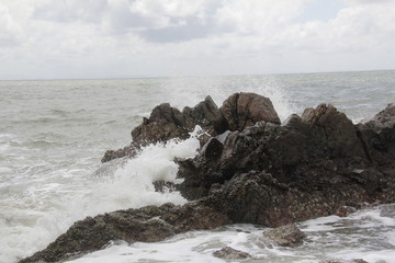 Great sea The sky and waves flow into the shore at intervals, with beautiful waves bubbling at the rocks to splash water.