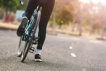 Crédence de cuisine en verre imprimé Vélo Femme à vélo sur une route dans le parc.