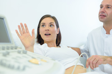 doctor doing ultrasound on belly of pregnant woman in clinic