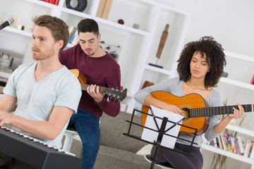 friends learning to play music instrument