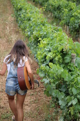 jeune femme qui joue de la guitare dans une vigne