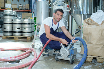 serviceman operating industrial water purification or filtration equipment