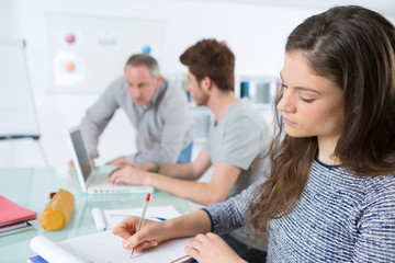 students are sitting in classroom and taking notes