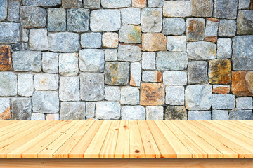 Wooden table and stone wall background.