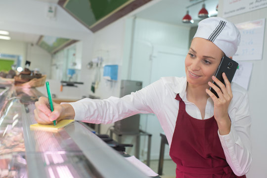 worker at a butchery using mobile phpe