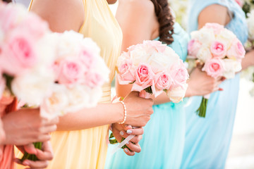 Obraz na płótnie Canvas Bridesmaid holding a bouquet of roses at the wedding.