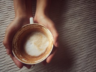 white cup of cappuccino on brown pattern table cloth,in vintage design,warm light tone,blurry light background