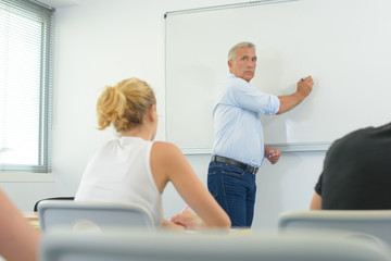 Obraz premium male teacher listening to students at adult education class