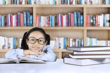 Elementary student sitting with book in library