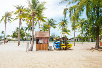 Life guard house on tropical beach with palm trees, blue sky and white sand.