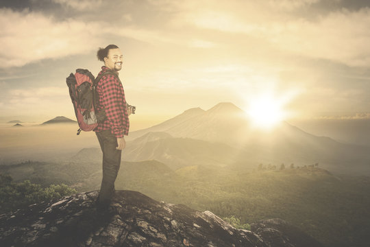 Man smiling on mountain at sunrise time