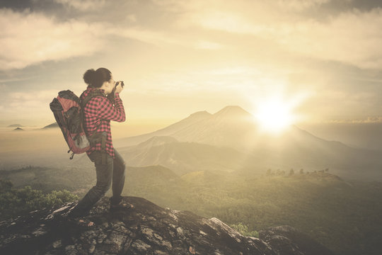 Man taking photo of sunrise view on mountain