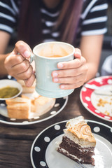 young woman enjoying latte coffee in cafe.
