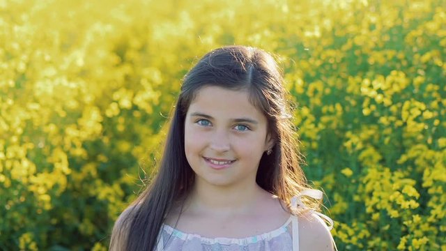 Pretty brunette posing with smile in the rape field