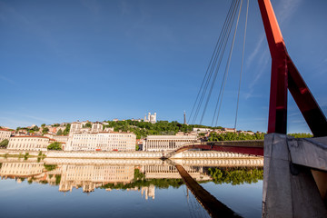 Morning view on the riverside with footbridge and palace in Lyon, France