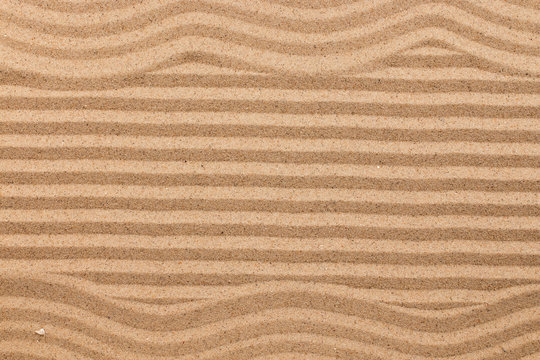 Frame made of zigzag on wavy sand.