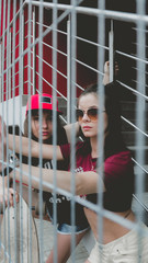 Two young Caucasian teen girls hanging out outside, urban background. Young active people lifestyle