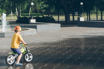 young boy riding strider bike