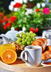 Obraz na płótnie Canvas Breakfast served with coffee, juice, croissants and fruits