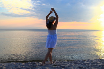 Fototapeta na wymiar молодая девушка на закате на берегу моря
