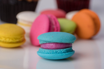 Colorful cupcakes and Macaroon on a white plate.