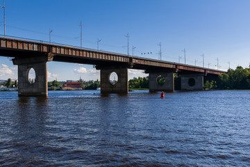 Bridge on a river against a blue sky and clouds
