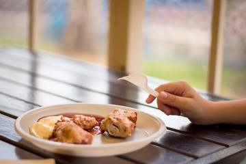 Boy takes piece of kebab from plate. Boy's hand with fork. cafe. Fast food