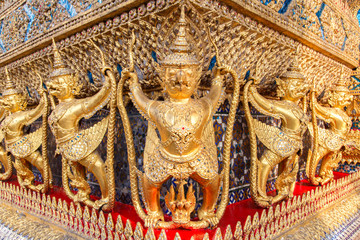 Fototapeta premium Perspective view of golden religious statue (Statue Garuda) in wat phra kaew temple, Bangkok, Thailand.
