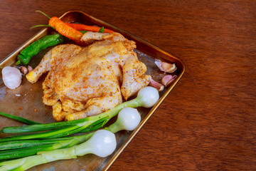 Cooking chicken with ingredients - carrot, herbs and spice before baking in the oven.