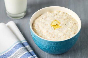Oatmeal with a Pat of butter in a blue bowl on the table	