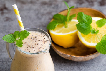 Banana and lemon smoothie, on the grey  background.