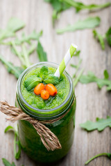 Rucola smoothie, on the grey  background.
