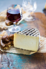 Sweet dessert liqueur wine in glass, hard french cheese Tomme de Montagne and dried figs with figs bread
