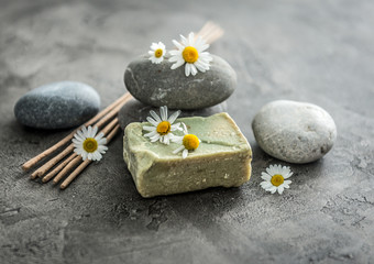 Fototapeta na wymiar Handmade soap with chamomile, smoking lavender sticks