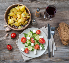 greek salad, wine, baked potatoes, topview