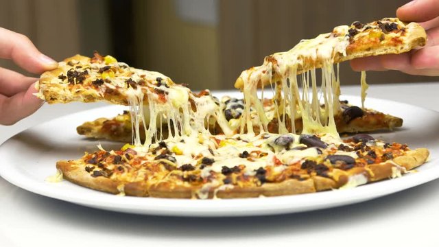 Two Hands Take Hot Pizza With Melted Cheese From The Plate