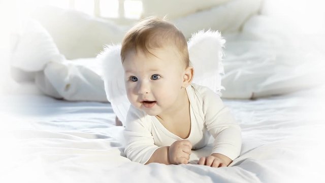 Baby angel funnung on the bed