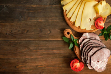 Slices of the delightful smoked ham and cheese on a wooden background