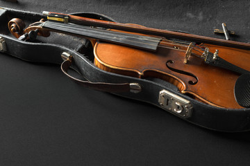 Naklejka na ściany i meble Old violin on a black background