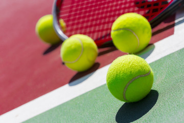 Tennis balls and racket on the grass court