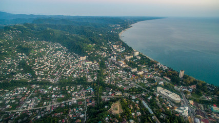 Fototapeta premium Landscape with night city of Sukhum Abkhazia from a height on a background of calm sea