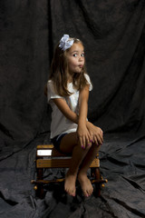 young girl in studio posing to camera with brown background 