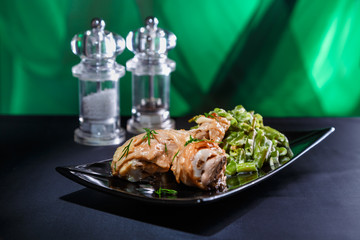 roasted chicken legs with green beans on a beautiful black plate with
