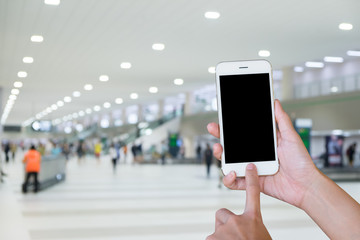 Hands woman are holding touch screen smart phone,tablet on Blurred Traveler at airport terminal for background.