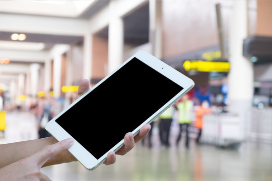 Hands woman are holding touch screen smart phone,tablet on Blurred Traveler at airport terminal for background.
