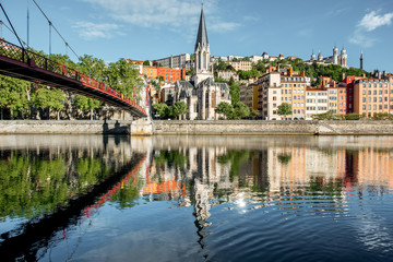 Fototapeta na wymiar Morning view on the riverside with saint George cathedral and footbridge in the old town of Lyon city