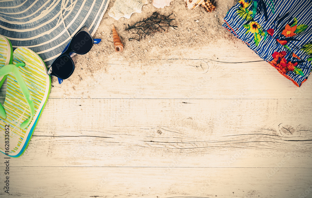 Wall mural Sand and shells and hat on the wooden floor, summer concept