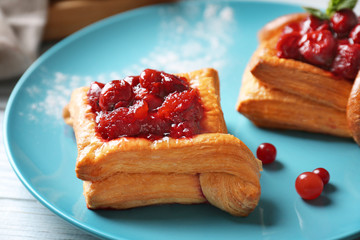 Blue plate with pastries and cherry, closeup